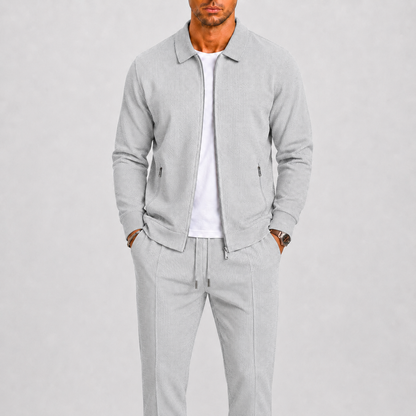 Model wears the light grey textured set, showing the collar, zip pockets and pintucked trousers 7