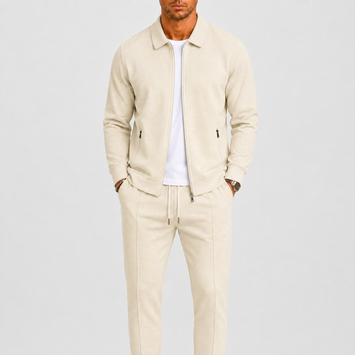 Model wears the cream waffle-textured zip jacket and drawstring trousers over a white t-shirt 1