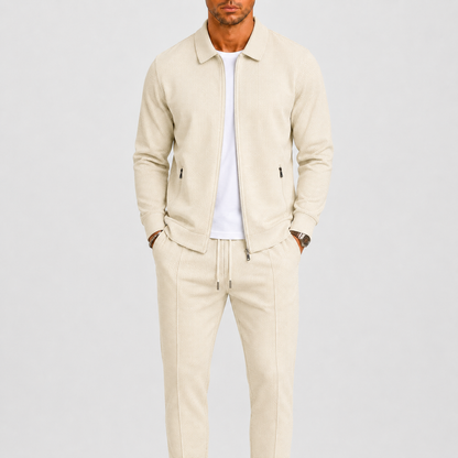 Model wears the cream waffle-textured zip jacket and drawstring trousers over a white t-shirt 1