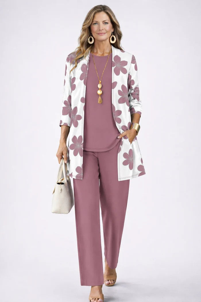 Model in dusky rose top and trousers with a white cardigan printed with large rose-coloured flowers 11