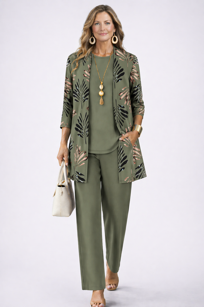 Model in an olive green set with a palm-leaf print open cardigan, holding a cream handbag 1