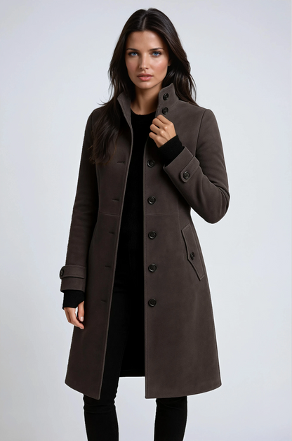 Model in a dark brown buttoned coat over black, holding the collar, close three-quarter view 2