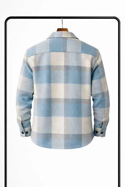 Back view of the pale blue, cream and grey checked overshirt on a hanger, showing the yoke and buttoned cuffs. 2