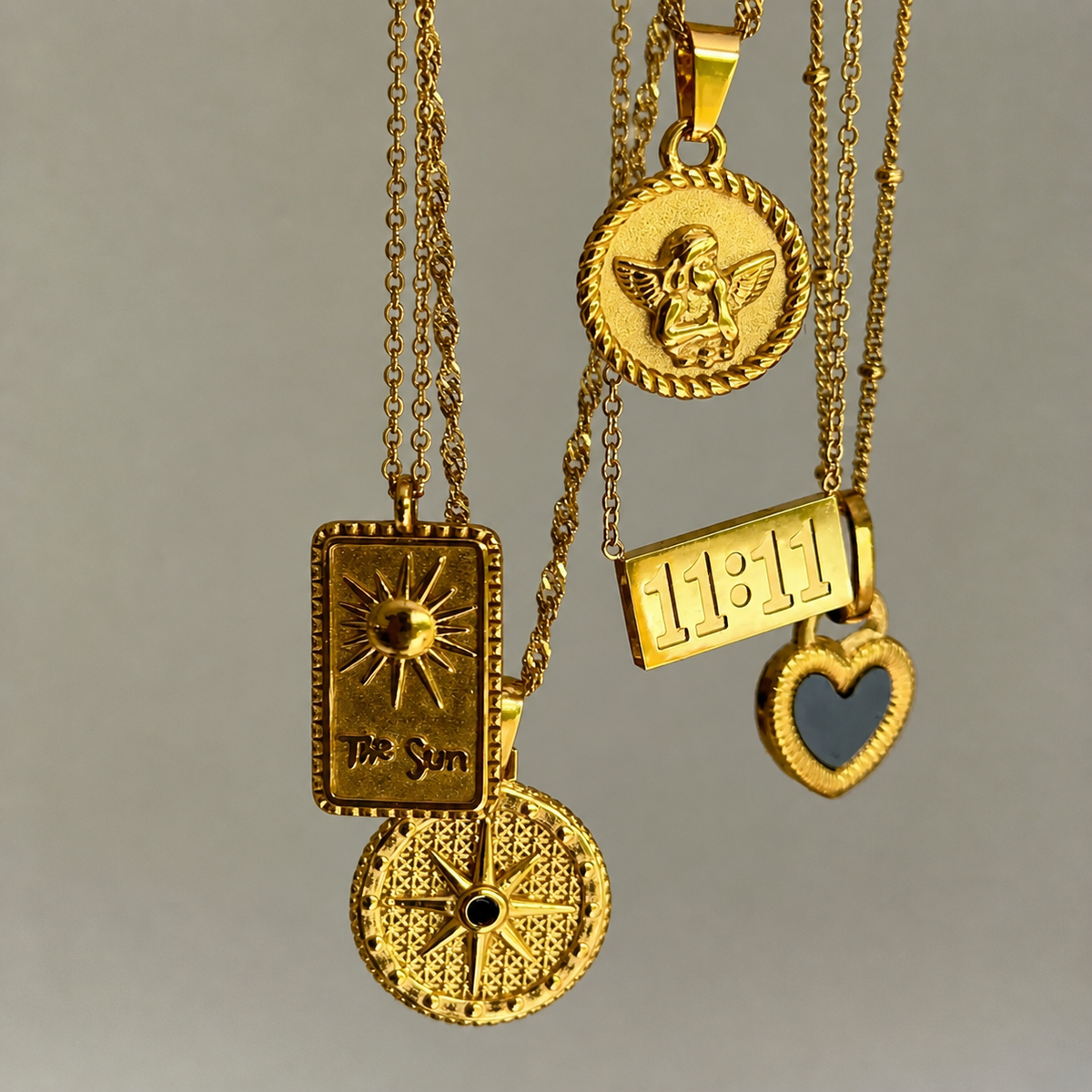 Star pendant hanging with other gold pendants, including a rectangular sun tag, an angel coin and a blue heart. 4