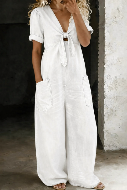 Front view of the jumpsuit on a model in white denim, with tie front and patch pockets 4