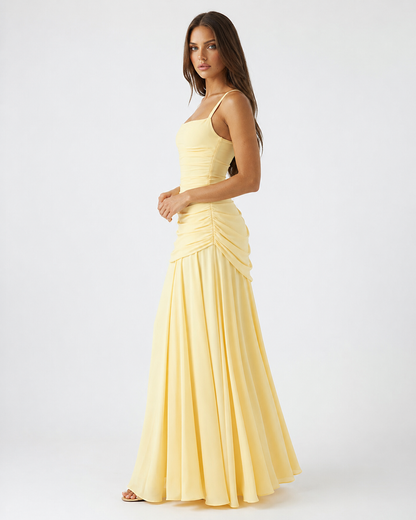 Side view of the pale yellow dress on a model, showing gathered ruching at the hip and full skirt. 3