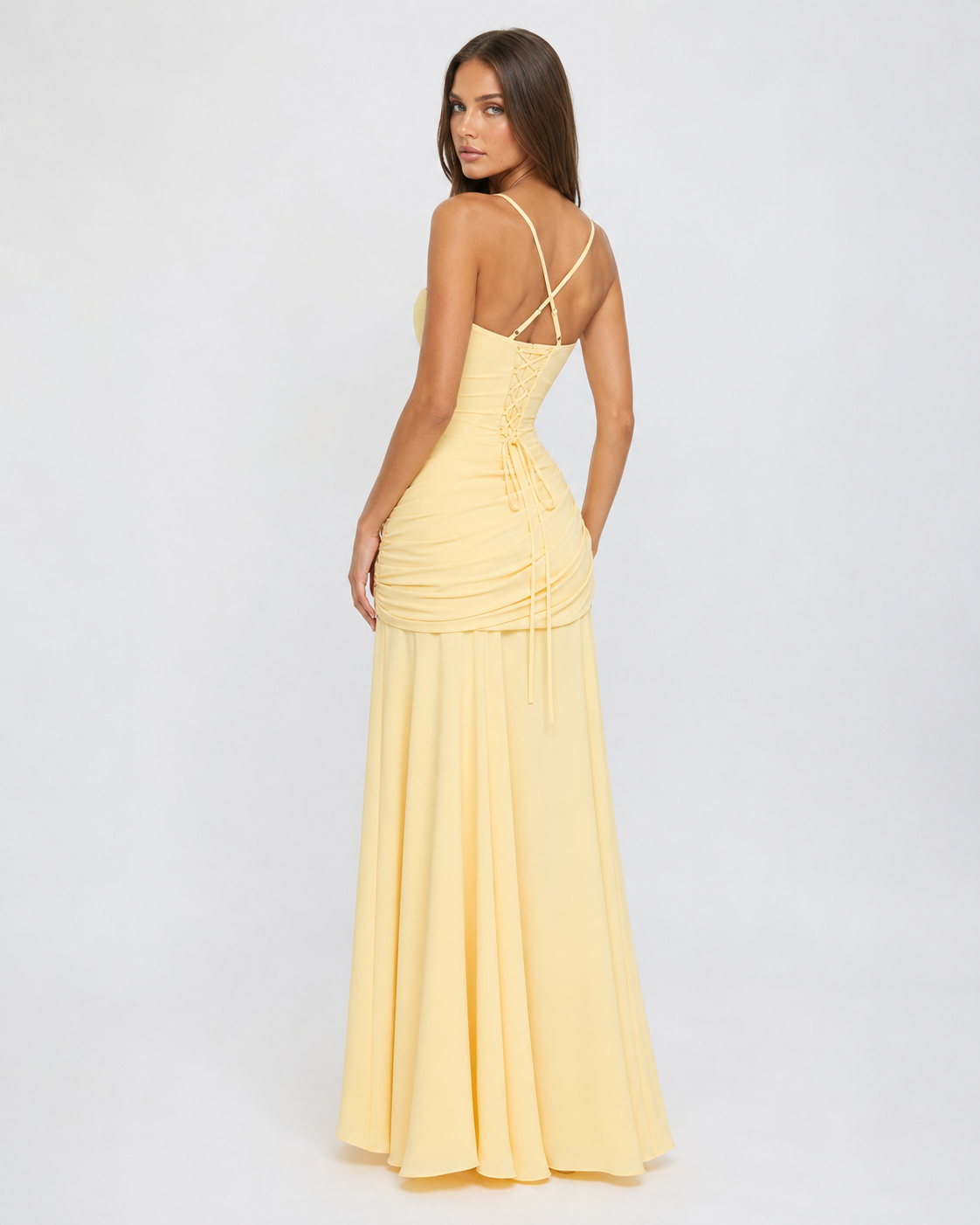 Back view of the pale yellow dress, showing the corset-style lace-up back, crossed thin straps and trailing ties. 4