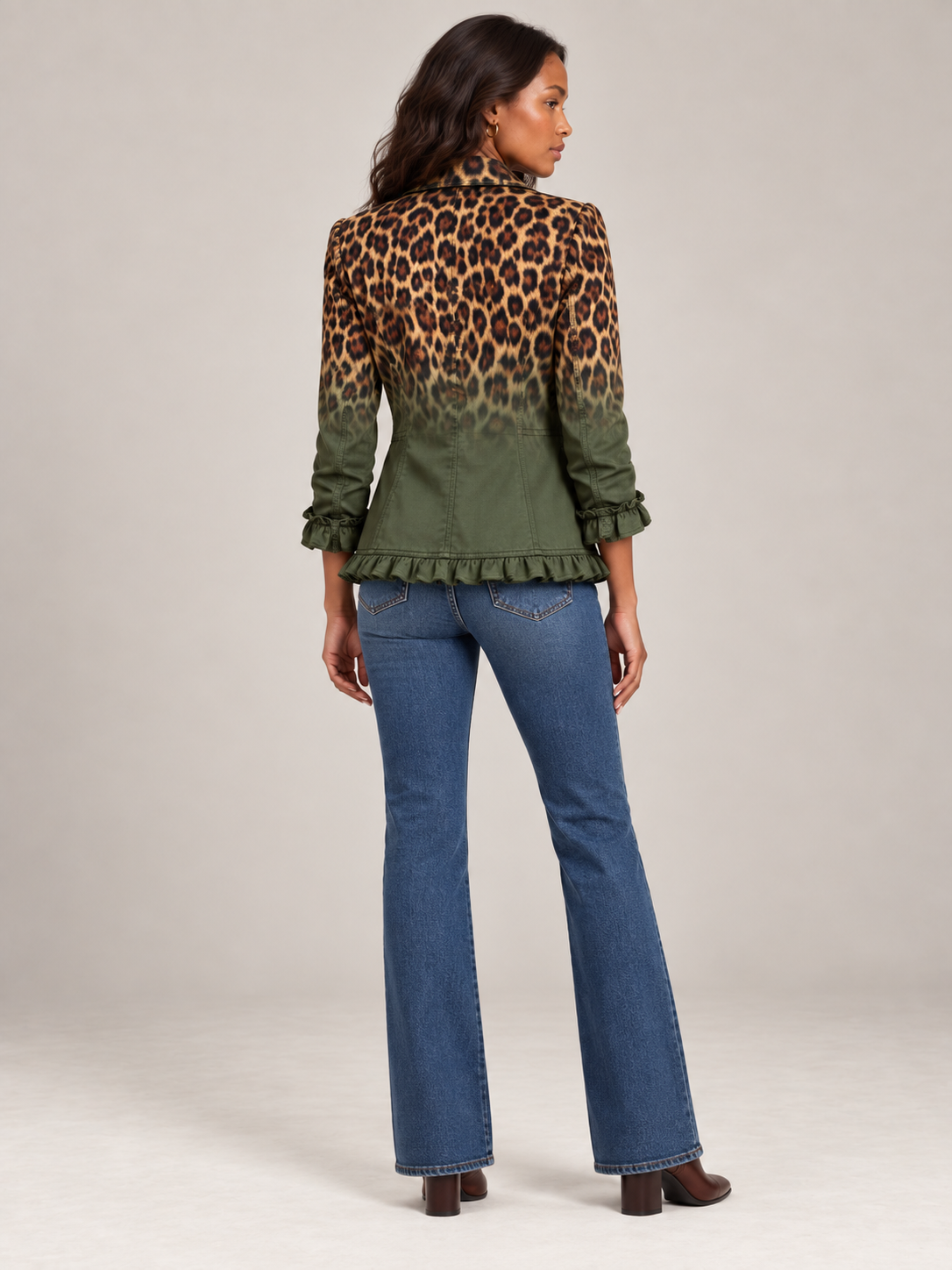 Back view of the green leopard blazer on a model, showing the ruffle trim at the hem and cuffs. 7