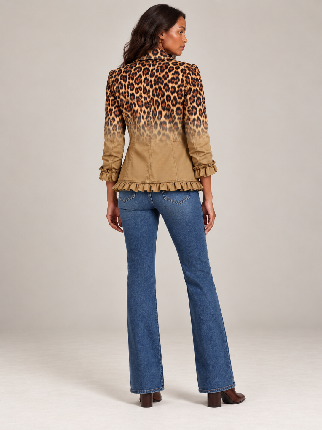 Back view of the camel leopard blazer on a model, with the print fading into plain fabric above the ruffled hem. 10