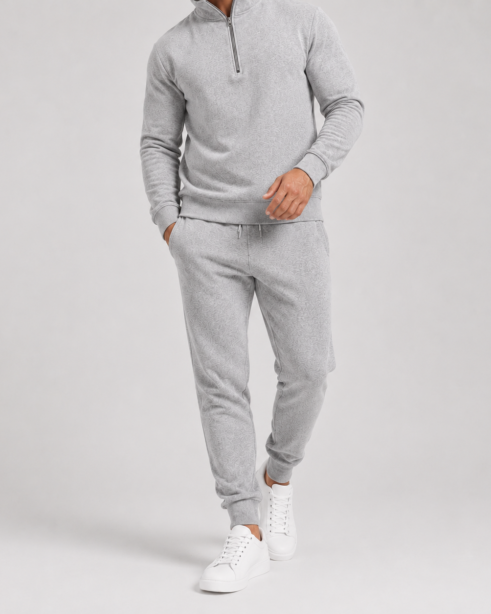 Cropped view of the grey marl tracksuit worn with white trainers, showing the textured fabric and drawstring waist 2