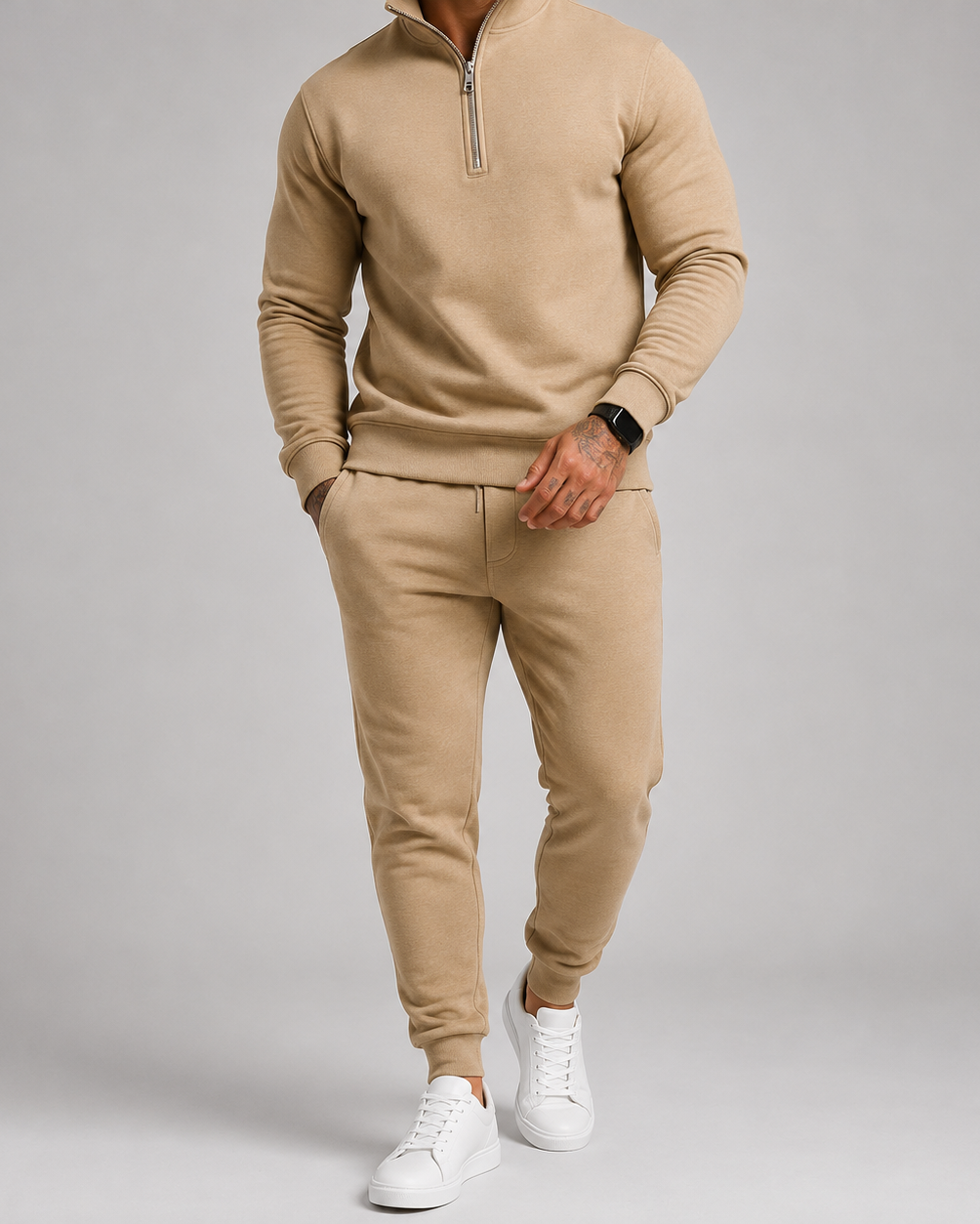 Model in the sand-coloured tracksuit with white trainers and a black smartwatch, hand resting by the pocket 5