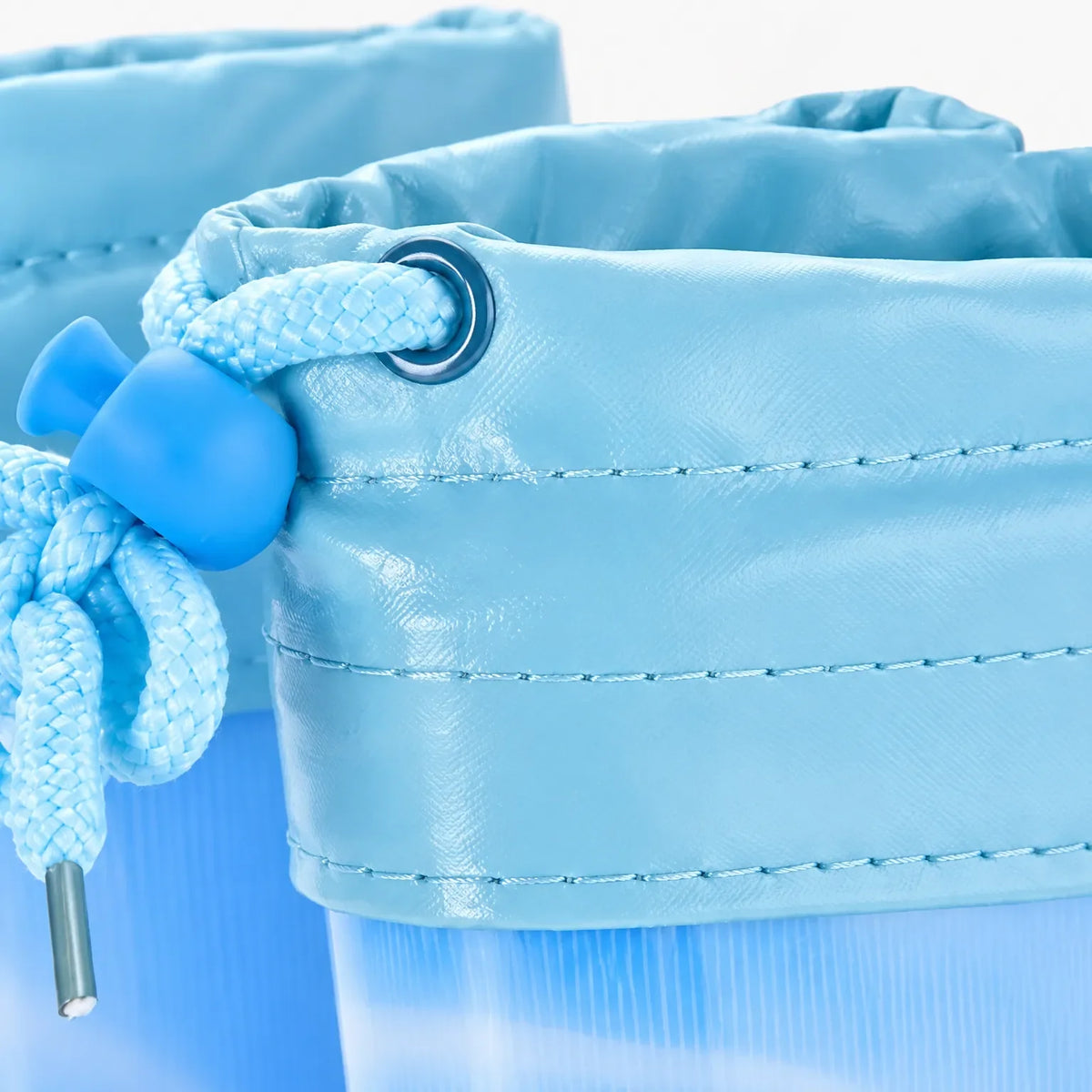 Close-up of a light blue welly's drawstring cuff, showing the metal eyelet, braided cord, toggle and stitched seams. 6