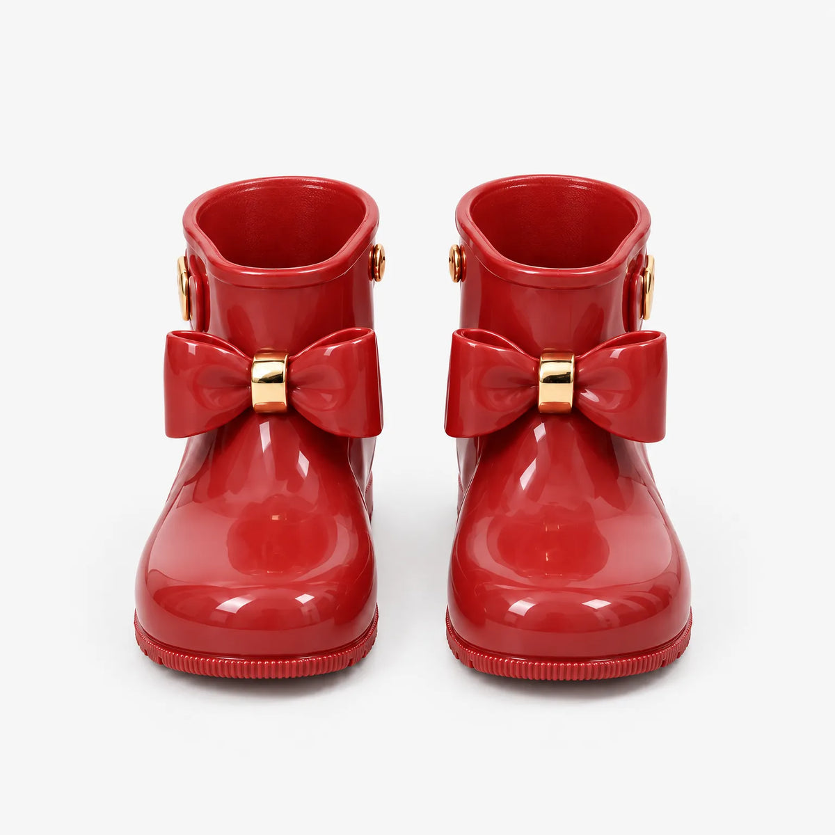 Front view of a pair of glossy red wellies with gold-trimmed bows, shown on a plain white background. 2