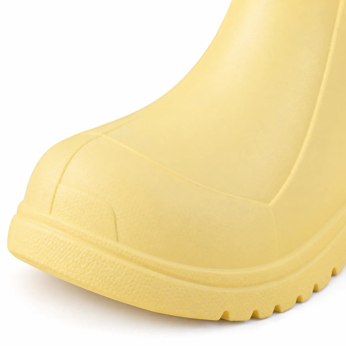 Close-up of the toe of a yellow welly, showing the moulded toe cap, textured surface and ridged sole edge. 6
