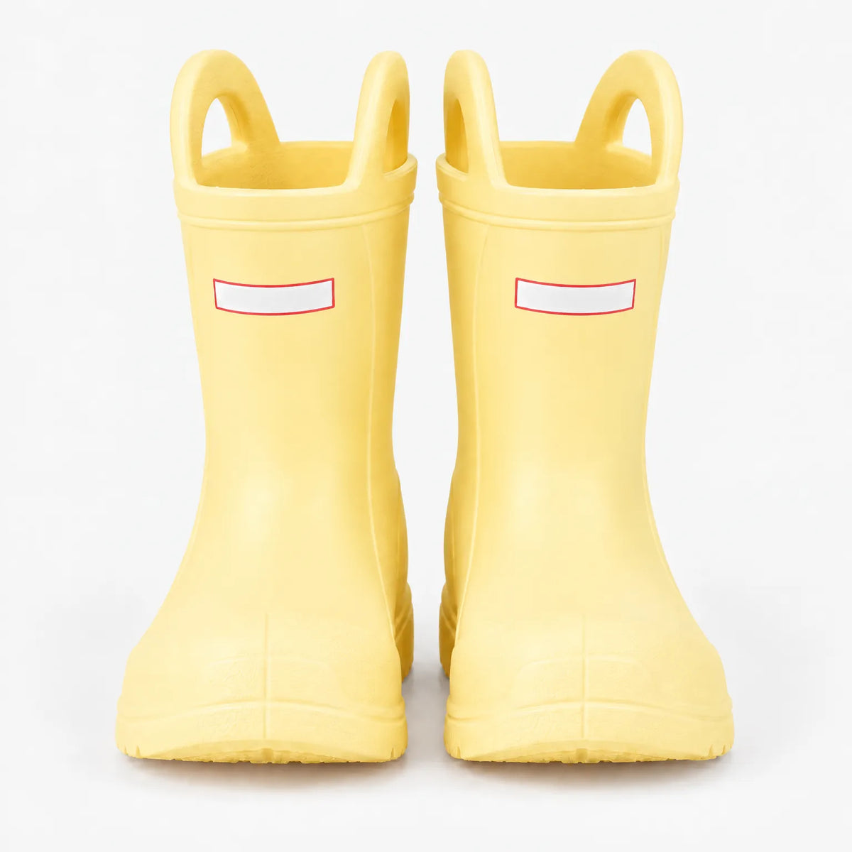 Front view of a pair of pale yellow wellies with two pull-on handles and blank white tabs on a plain background. 9