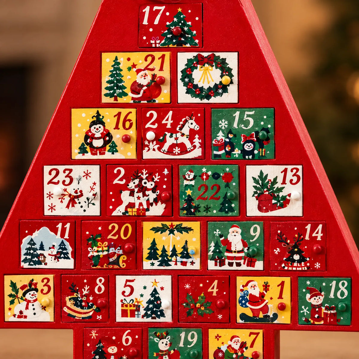 Close-up of the painted numbered drawers, each with a small round knob and a festive scene such as Santa, a snowman or a rocking horse. 3