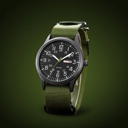 Angled view of the black-dialled watch with olive woven strap, shown against a dark green studio background. 4