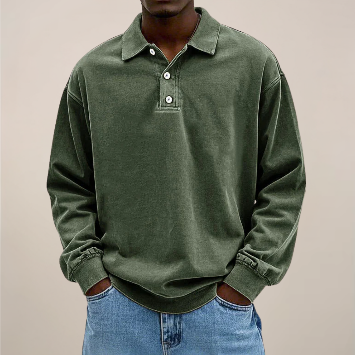 Model wearing the relaxed-fit long sleeve polo in washed olive green, hands in the pockets of light blue jeans. 2