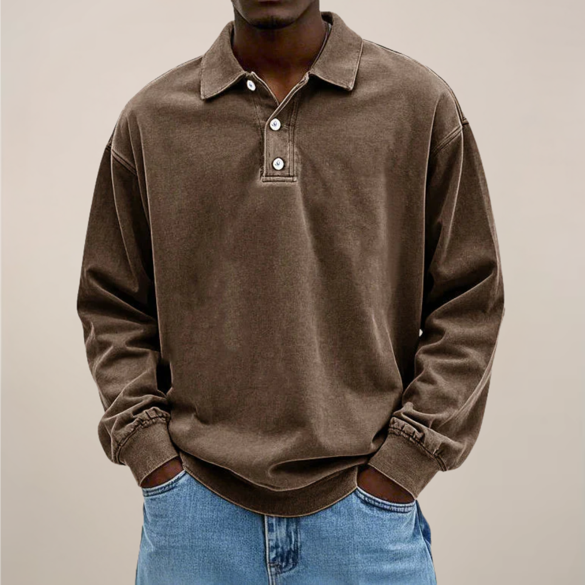 Model wearing the relaxed-fit long sleeve polo in washed chocolate brown, hands in the pockets of light blue jeans. 3