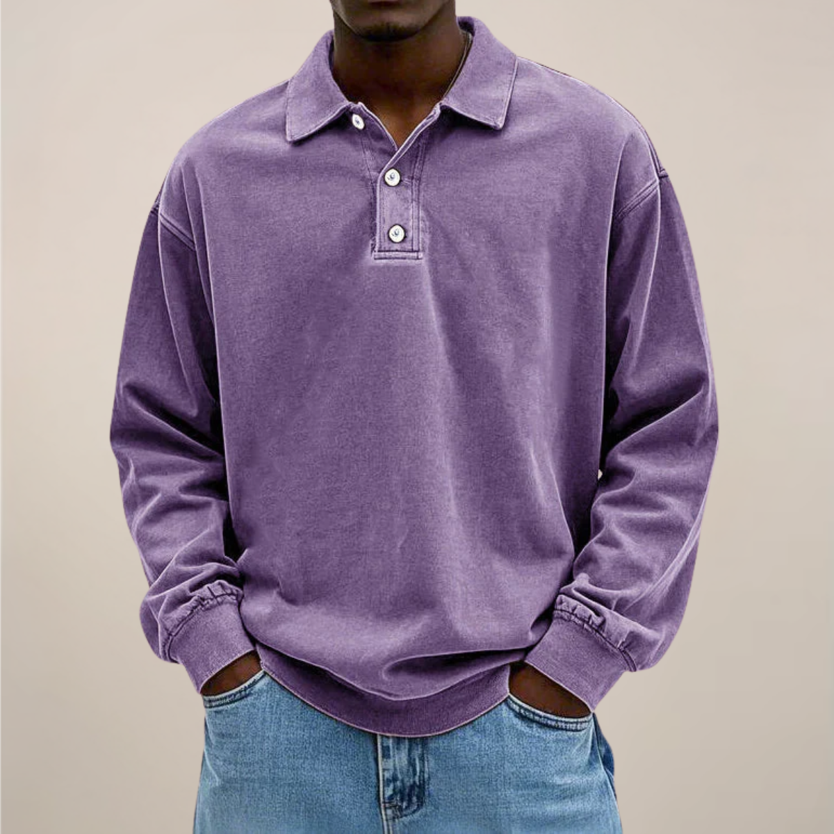 Model wearing the relaxed-fit long sleeve polo in washed lilac purple, hands in the pockets of light blue jeans. 4