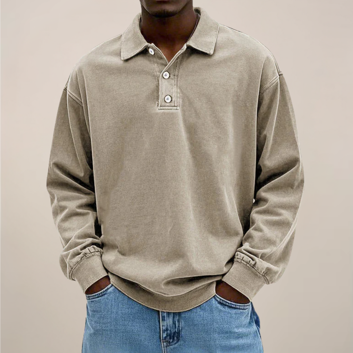 Model wearing the relaxed-fit long sleeve polo in washed sandy beige, hands in the pockets of light blue jeans. 6