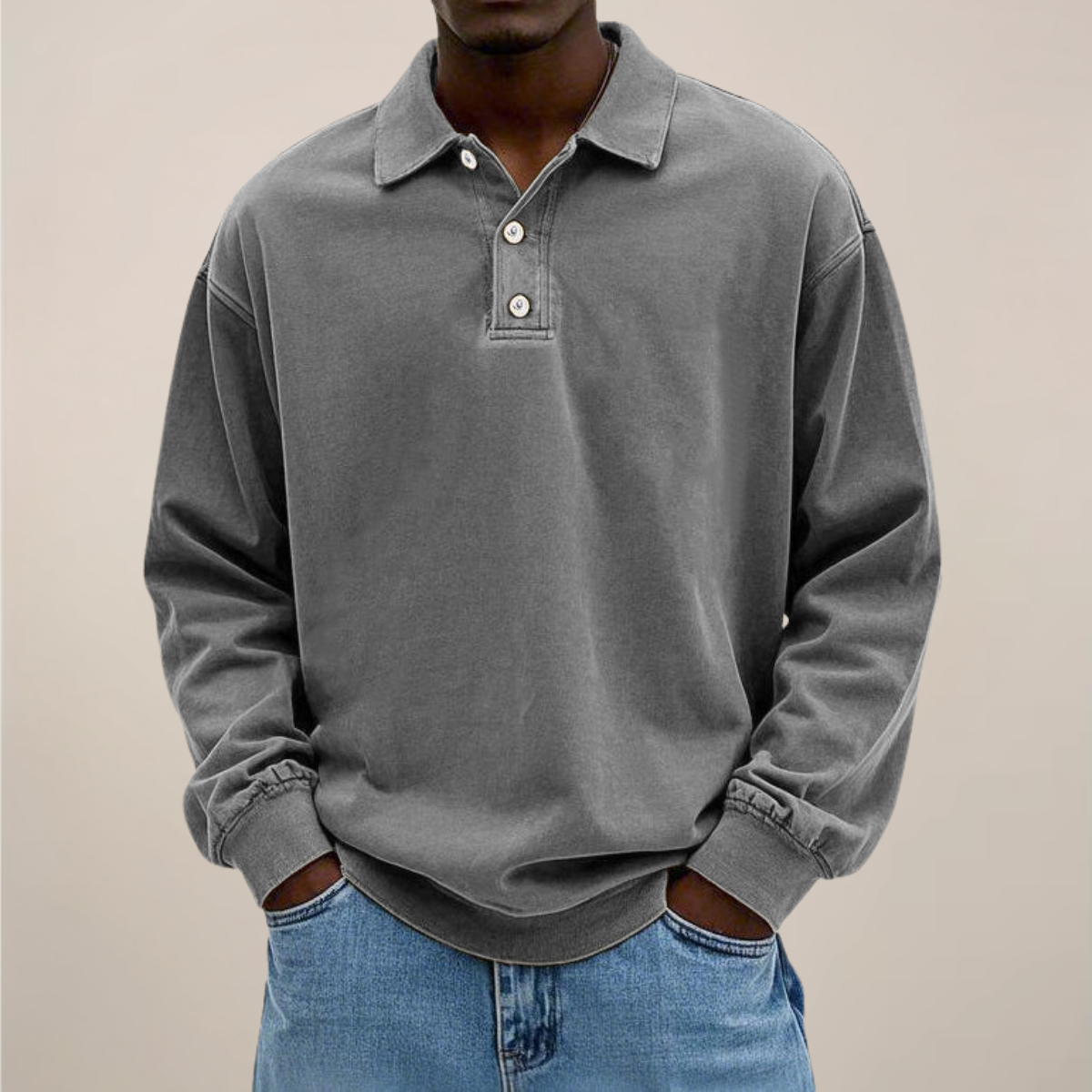 Model wearing the relaxed-fit long sleeve polo in washed mid grey, hands in the pockets of light blue jeans. 7