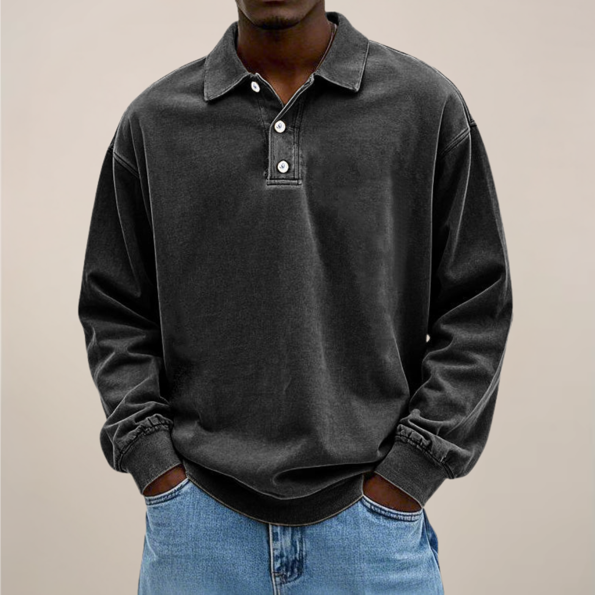 Model wearing the relaxed-fit long sleeve polo in washed charcoal black, hands in the pockets of light blue jeans. 8