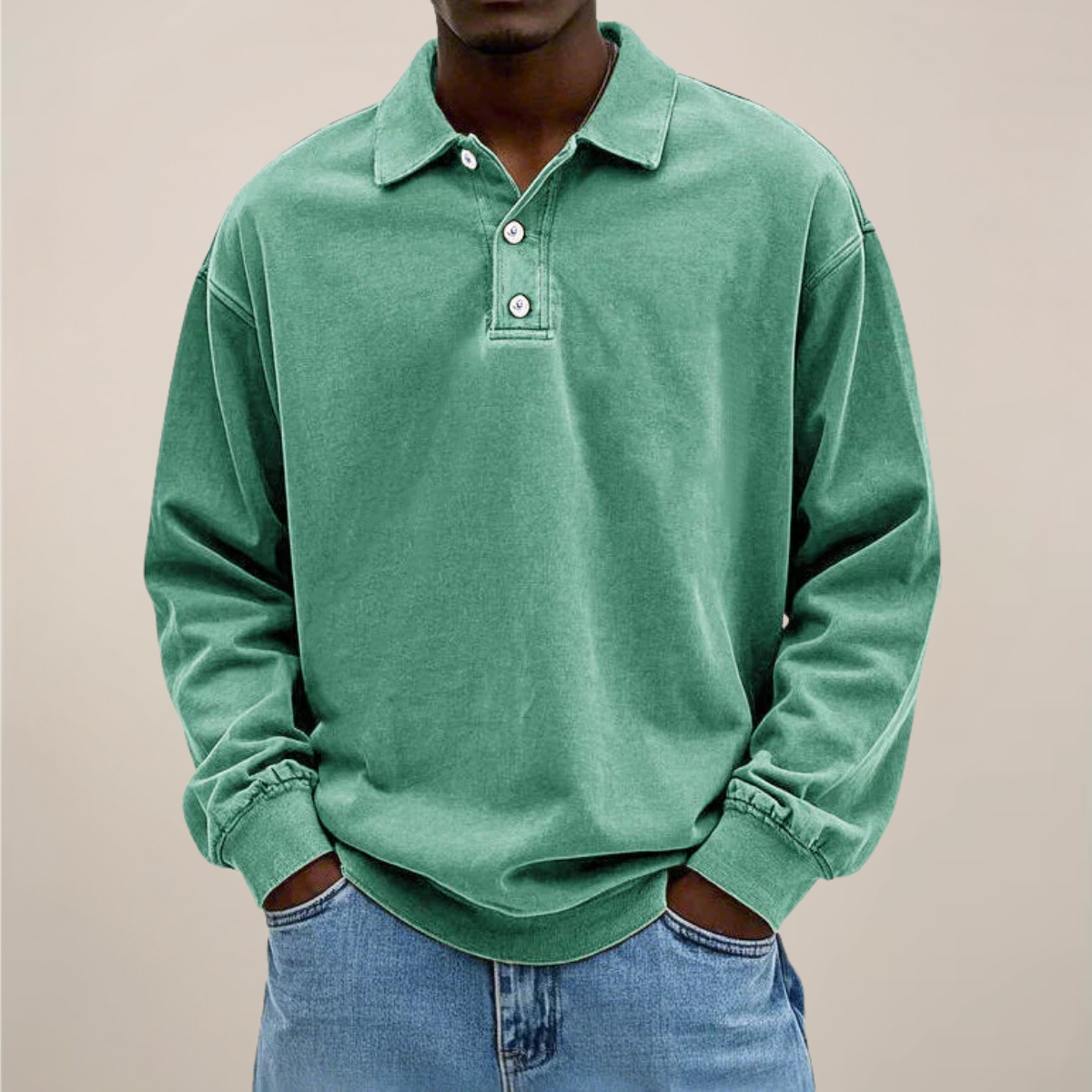 Model wearing the relaxed-fit long sleeve polo in washed sage green, hands in the pockets of light blue jeans. 9