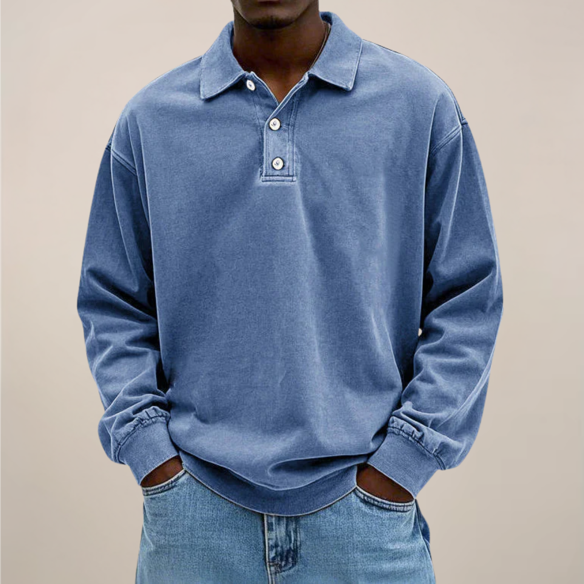 Model wearing the relaxed-fit long sleeve polo in washed denim blue, hands in the pockets of light blue jeans. 1