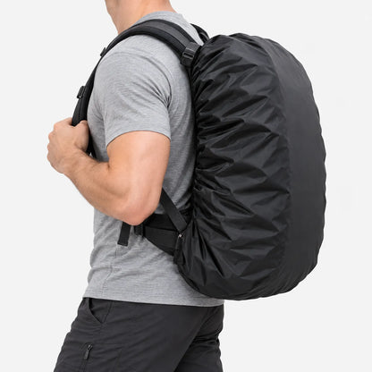 Side view of a man in a grey t-shirt and dark trousers carrying a backpack fitted with a black cover against a white background. 4