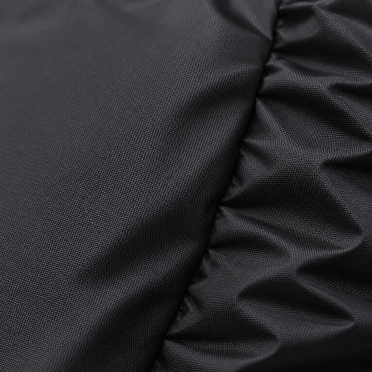 Close-up of the black cover's fabric, showing its fine woven texture and a gathered, elasticated fold at the edge. 5