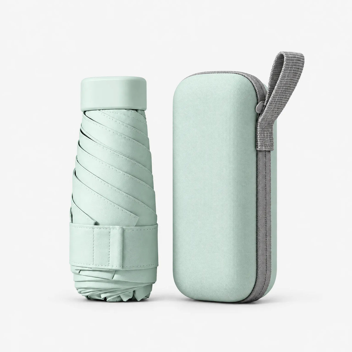 Folded mint green umbrella with a Velcro strap standing beside its matching hard zipped case with a grey carry loop. 2