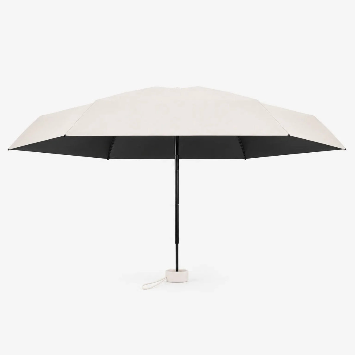 Open cream umbrella seen from the side, showing the black underside of the canopy, black shaft and cream handle with cord. 4