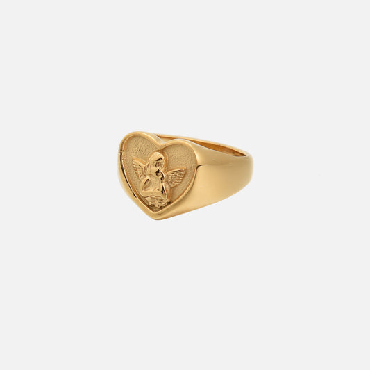 Gold heart-shaped signet ring with a raised winged cherub relief on a textured heart, shown at an angle on a plain white background. 1