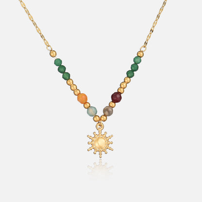 Front view of a gold-tone chain necklace with a beaded section and dotted sun pendant 1