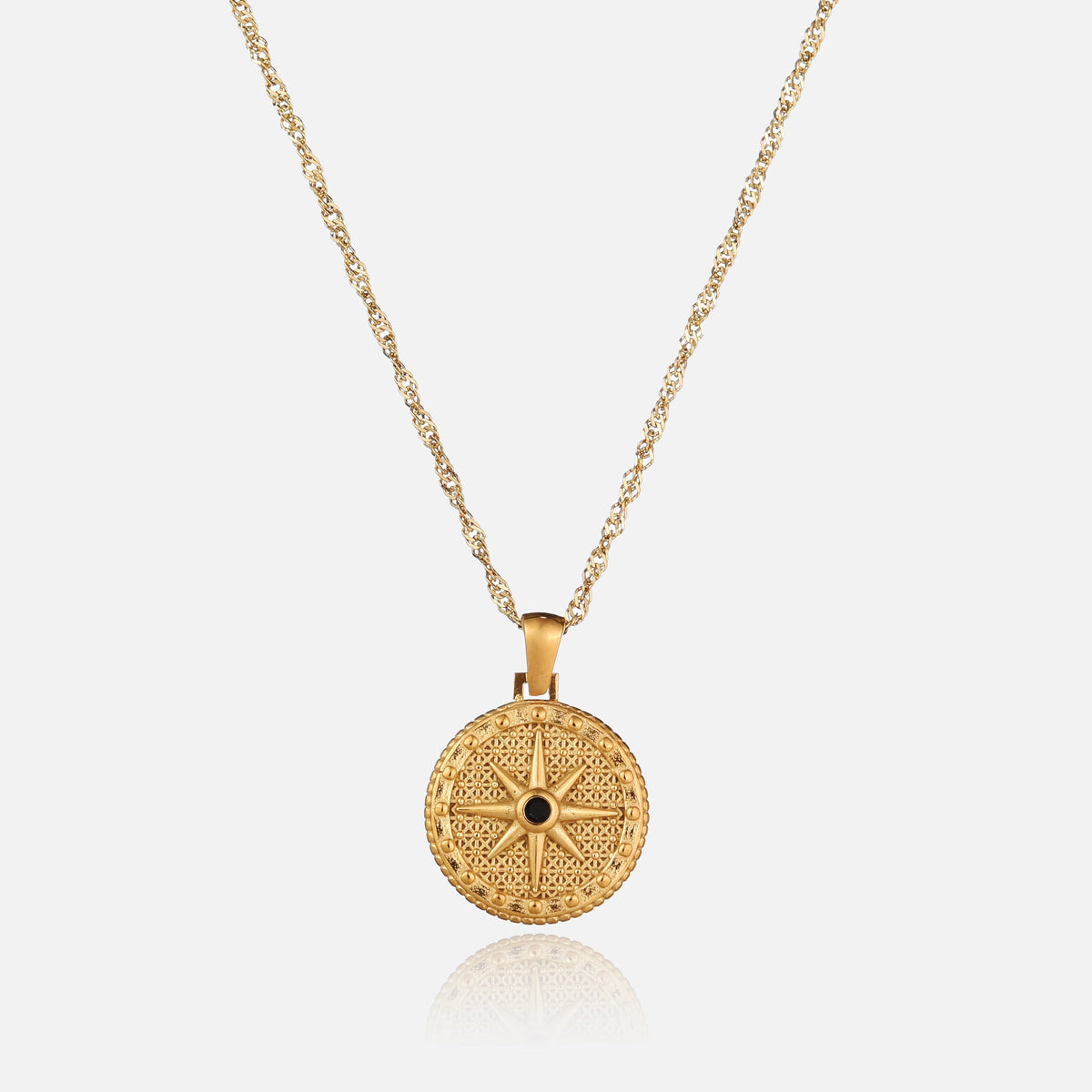 Front view of a round gold pendant with a raised eight-pointed star and black stone, hanging from a twisted chain. 1