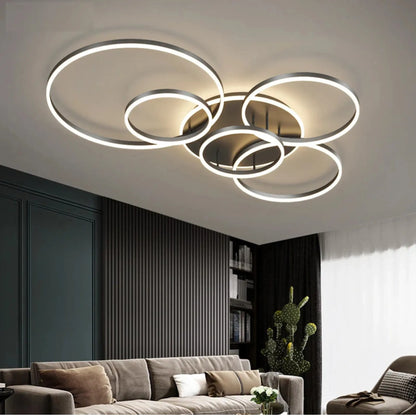 Glowing overlapping rings in a dark-framed finish on a living room ceiling above a taupe sofa 1