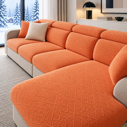 Orange textured stretch covers on a corner sofa with chaise, cream cushion beside a snowy window 1