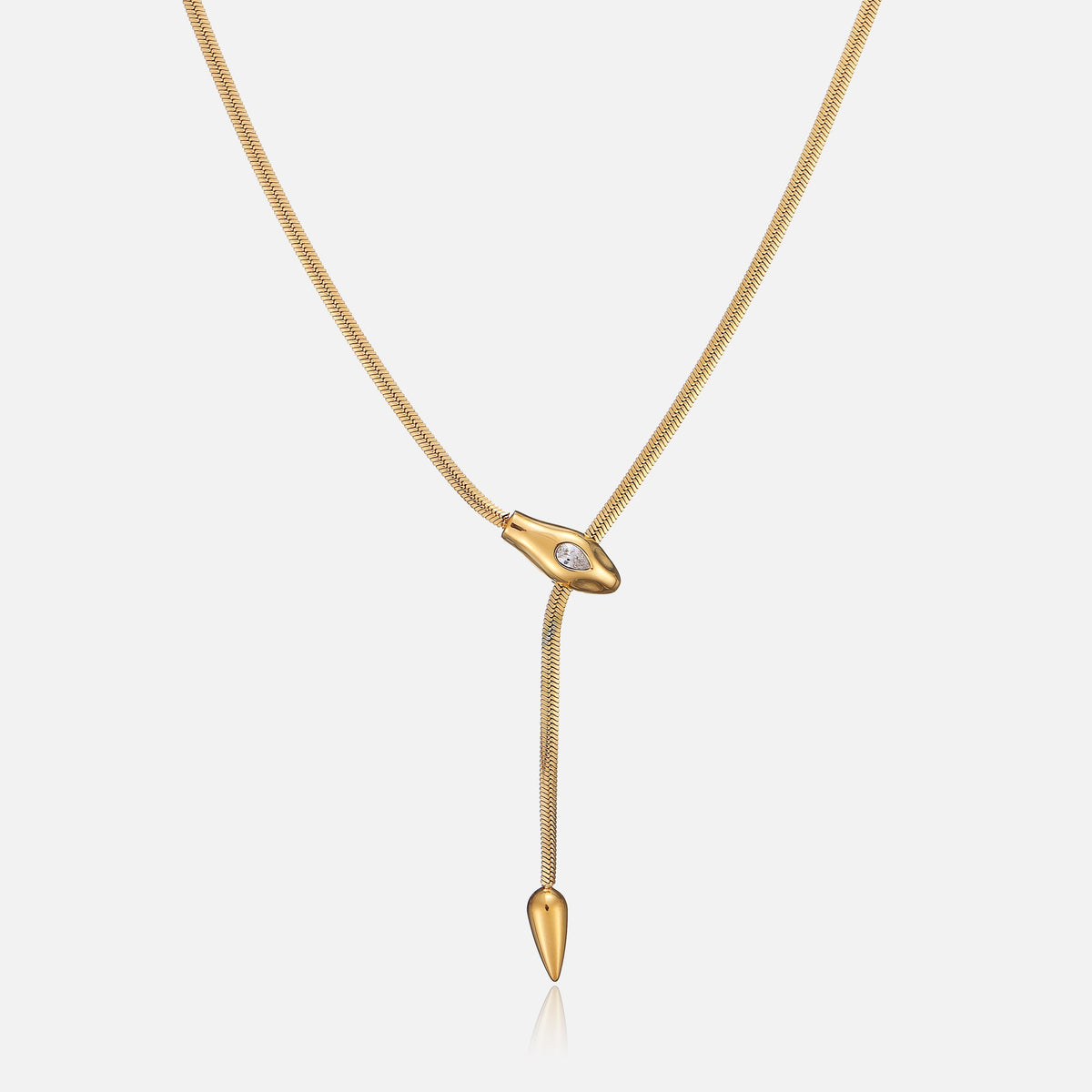 Gold-tone lariat necklace with flat snake chain, snake-head slider set with a clear teardrop stone, front view 1