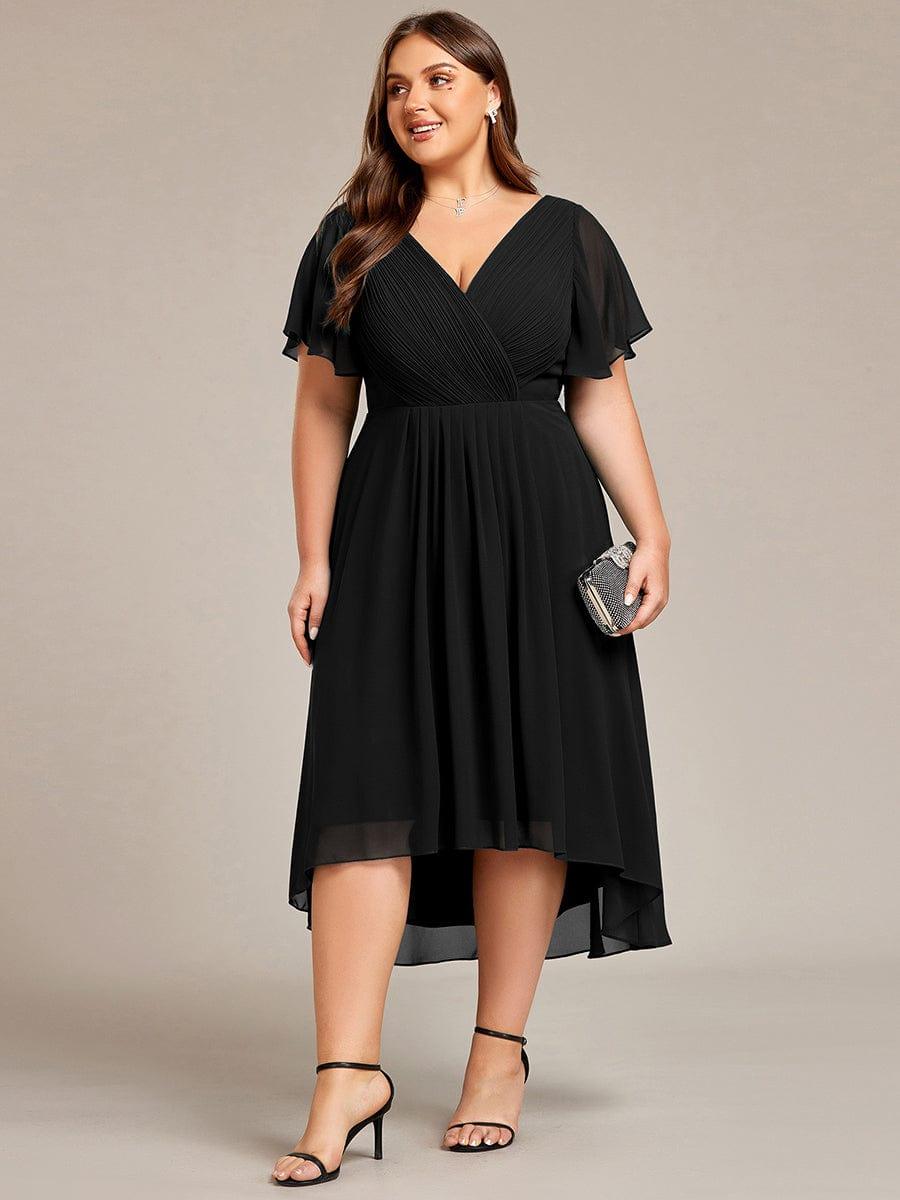 Plus-size model in the black dress holding a sparkly clutch, front view with the high-low hem and black heels. 30