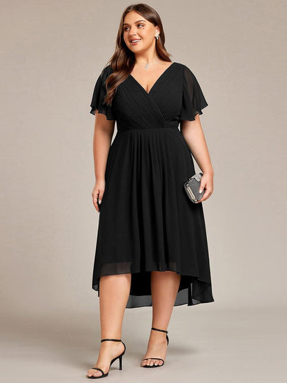 Plus-size model in the black dress holding a sparkly clutch, front view with the high-low hem and black heels. 30
