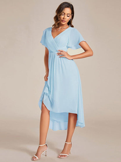 Light blue chiffon dress on a model with one hand on her hip, lifting the skirt to show the layered high-low hem. 88