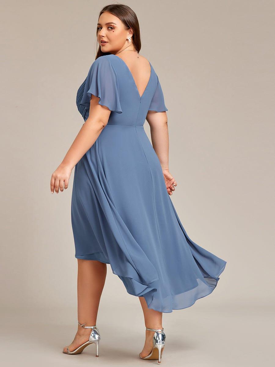 Back view of the dusty blue high-low dress on a plus-size model, showing the V-shaped back, zip and flutter sleeves. 42