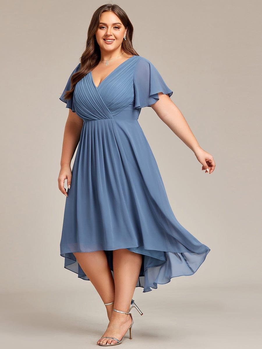 Dusty blue chiffon dress on a plus-size model mid-twirl, the asymmetric high-low hem swirling around her. 45
