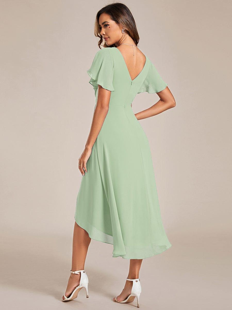 Back view of the sage green dress, showing the V-back with zip and the longer, flowing rear hem. 77