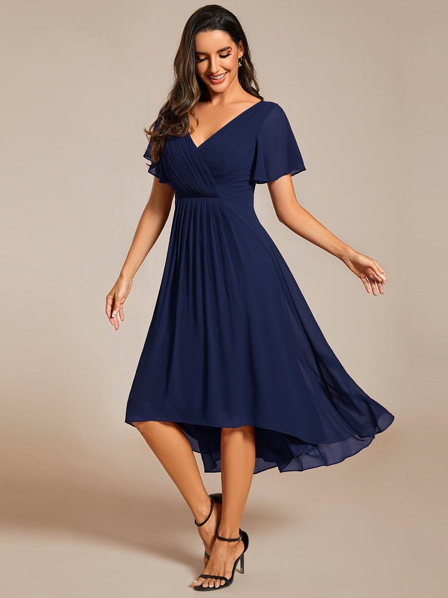 Model in the navy blue high-low chiffon dress with black heels, looking down as the skirt sways. 52
