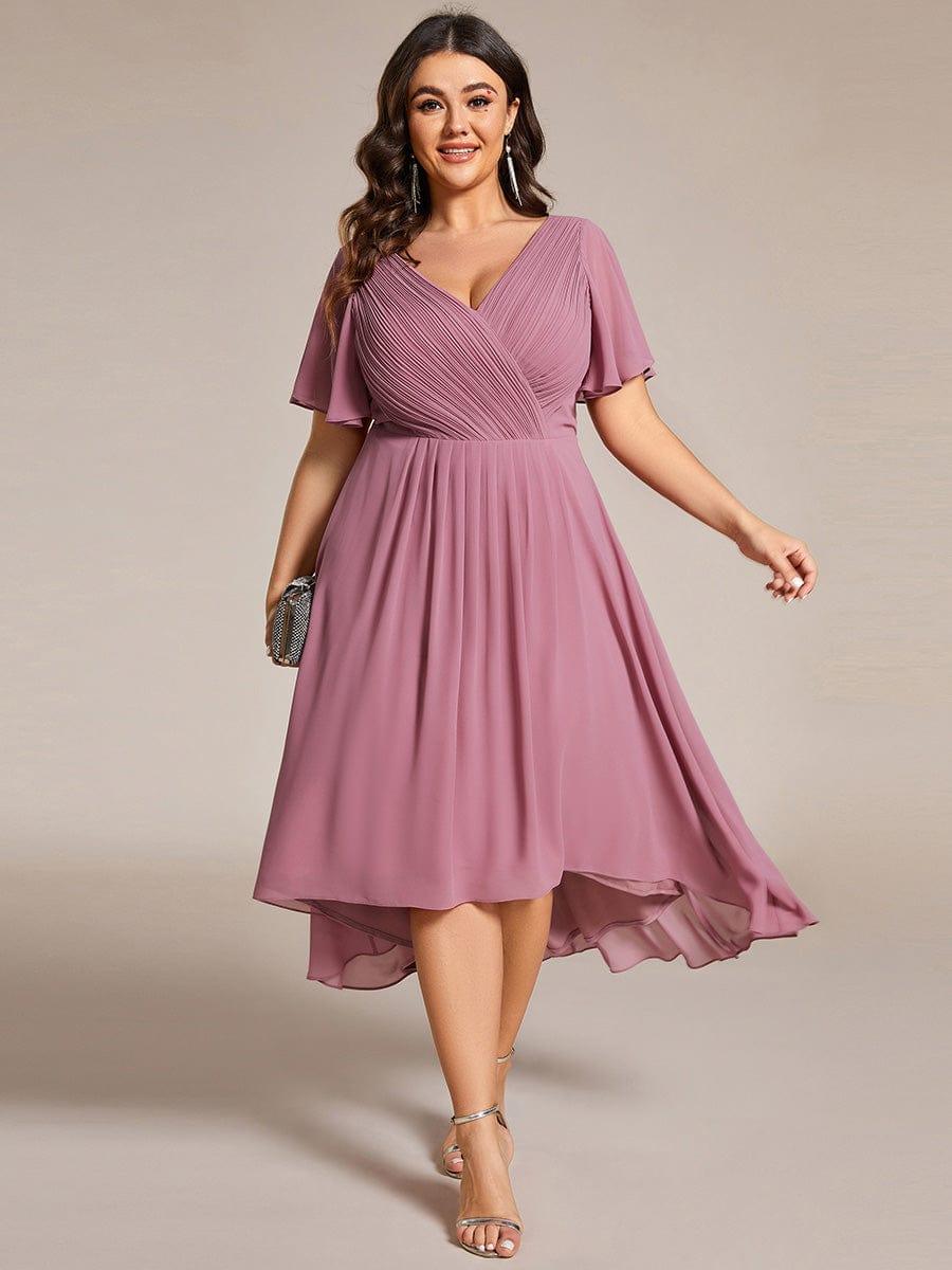 Plus-size model in the dusky mauve pink high-low chiffon dress, holding a sparkly clutch and wearing strappy heels. 63