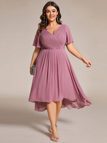 Plus-size model in the dusky mauve pink high-low chiffon dress, holding a sparkly clutch and wearing strappy heels. 63