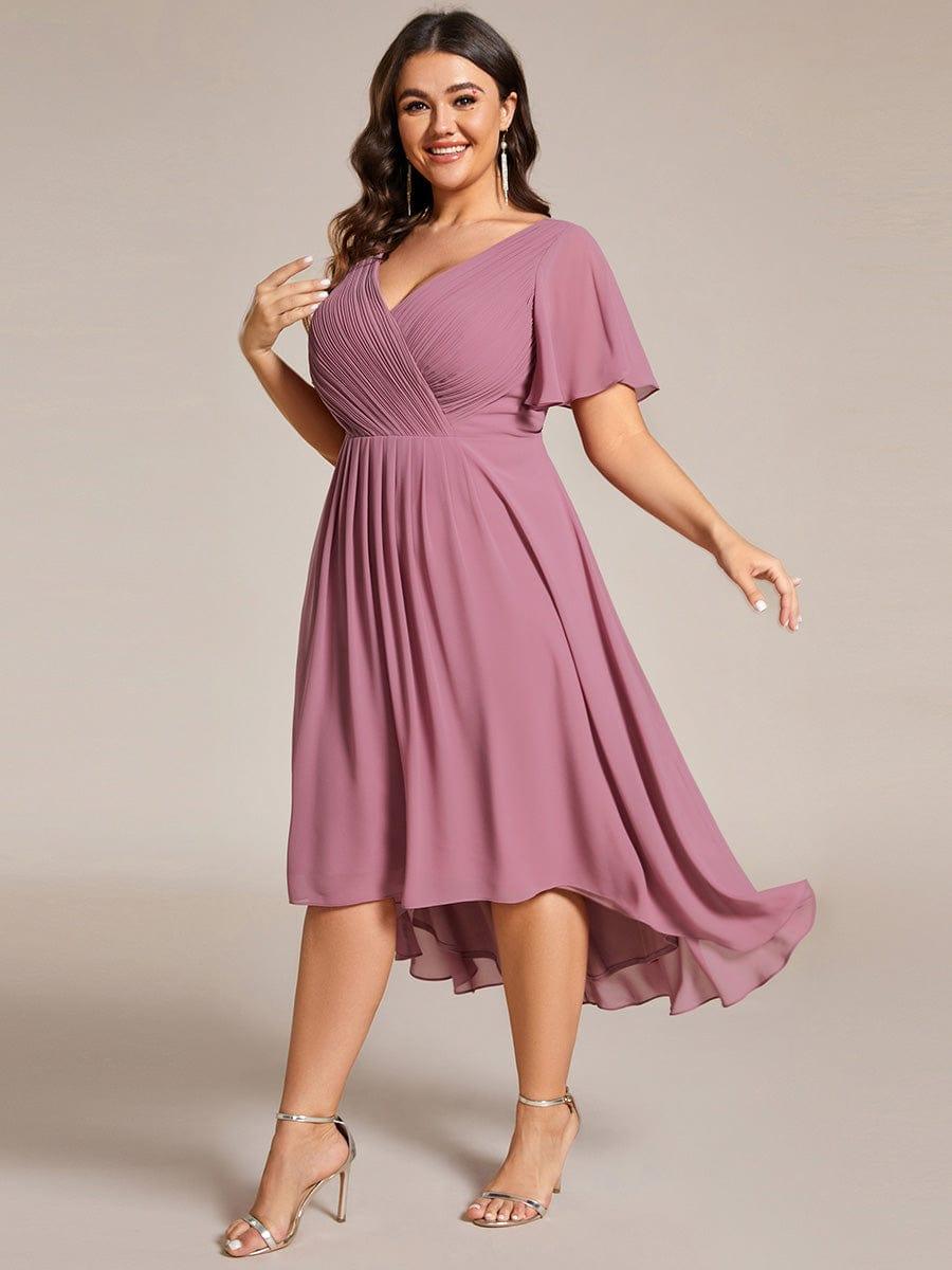 Plus-size model in motion in the mauve pink dress, skirt swirling to show the longer back hem and silver sandals. 67