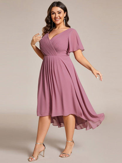 Plus-size model in motion in the mauve pink dress, skirt swirling to show the longer back hem and silver sandals. 67